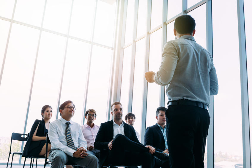 Man talking to coworkers in conference hall